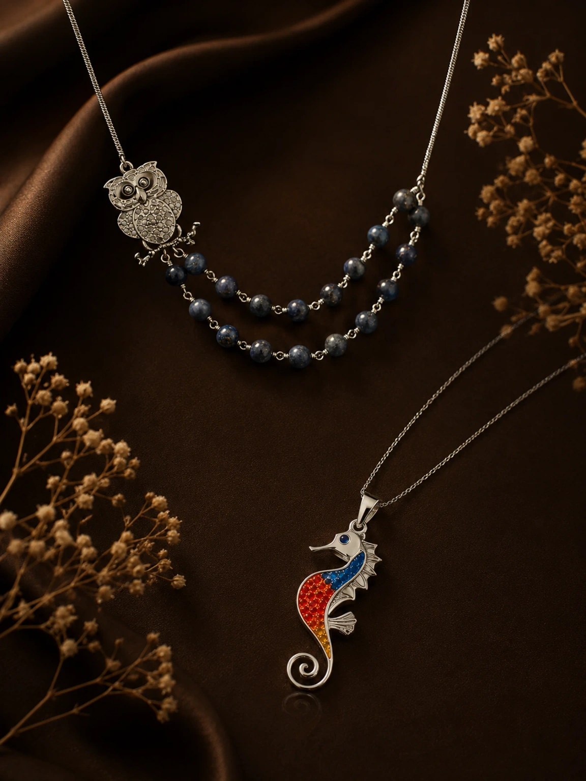 Layered silver necklaces with an owl pendant, beaded strands and an enamel seahorse charm